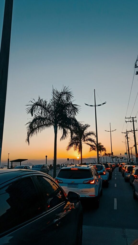 carro indo em direção ao por do sol lindo na cidade nesse wallpaper para celular