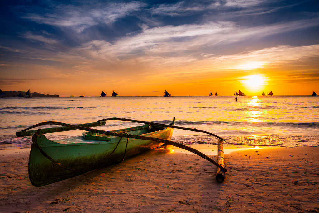 wallpaper de pc com barco na praia iluminada por do sol